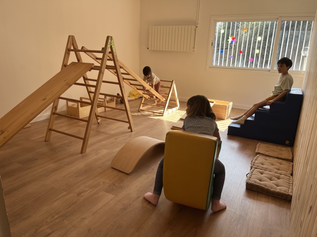 Infants jugant amb rampes i estructures de moviment
